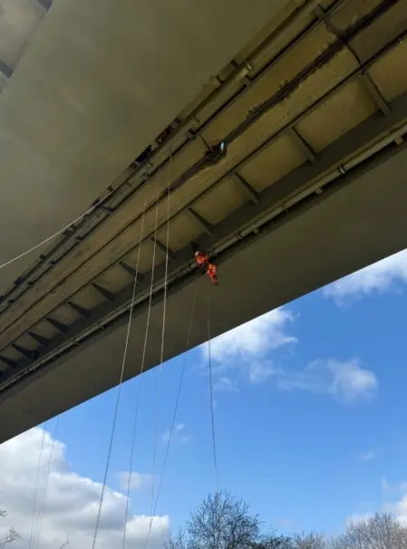Close-up of a rope access technician wearing full safety equipment