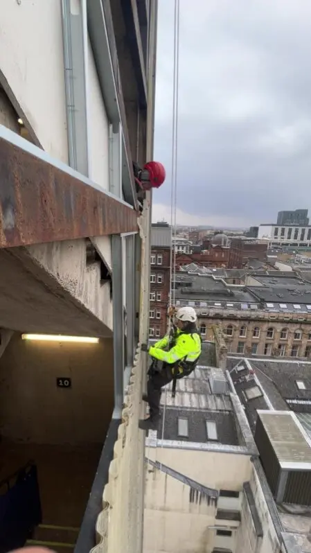 Rope access technician carrying out a structural inspection at height